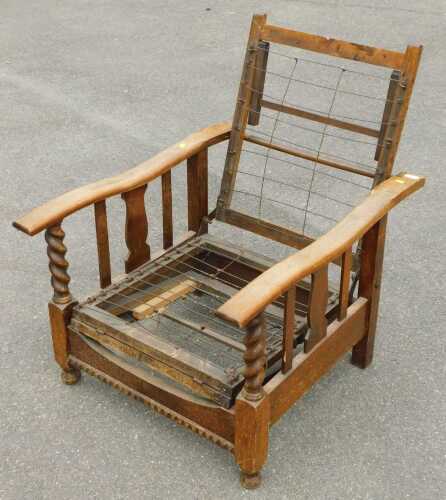 An early 20thC oak adjustable armchair, lacking cushions.