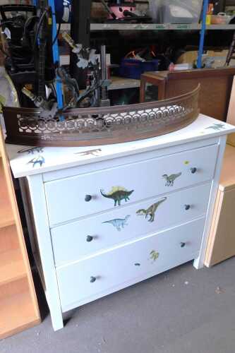 A white painted three drawer chest, together with a fire fender, and a twin sconce wall light. (3)