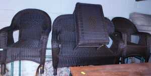 A wicker conservatory set, comprising two seater sofa, two armchairs, and a two tier table.