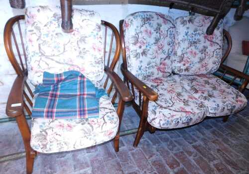 An Ercol style cottage suite, comprising a two seater settee and armchair. 
The upholstery in...