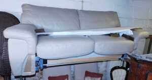 A tooled leather two seater sofa bed, with a mattress.