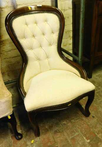 A Victorian style mahogany framed spoonback nursing chair, with an upholstered button back and...