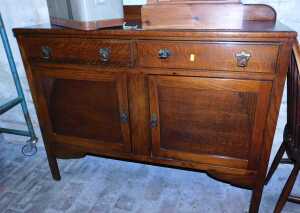 An early 20thC oak sideboard, the base with two drawers above two panelled cupboards, raised on...