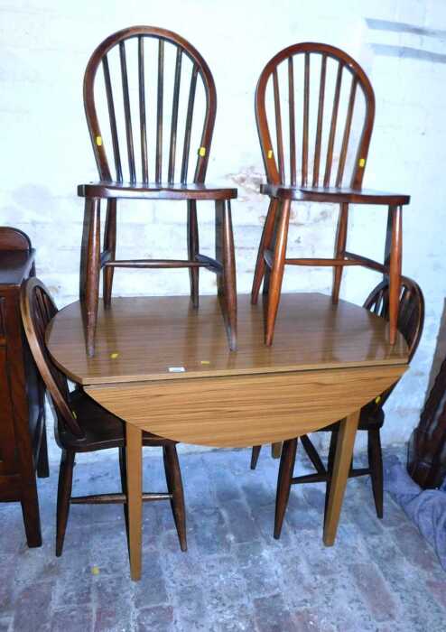 A drop leaf kitchen table, together with a set of four looped spindle back dining chairs.