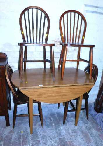 A drop leaf kitchen table, together with a set of four looped spindle back dining chairs.