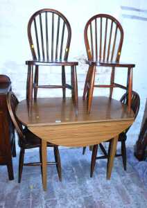 A drop leaf kitchen table, together with a set of four looped spindle back dining chairs.