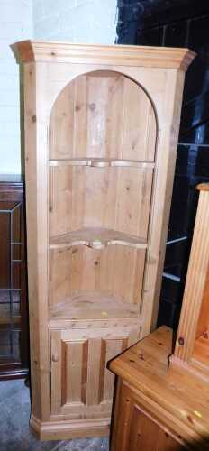 A 20thC waxed pine corner cabinet, the top with a moulded pediment above two shaped shelves,...
