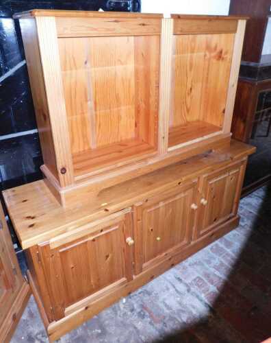 A pine sideboard, with three panelled doors to the base, raised on a plinth, 70cm high, 153cm...