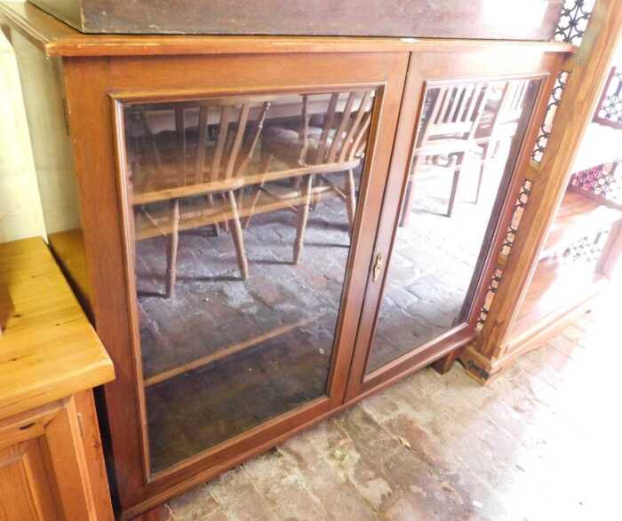 A mahogany display cabinet, the glazed doors enclosing three shelves, raised on tapering legs,...