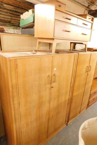 An E Gomme G-Plan oak part bedroom suite, comprising a pair of double wardrobes, and a dressing...