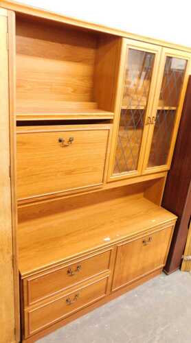 An oak veneer room unit, the top with two glazed doors flanked by a recess and a fall, the base...