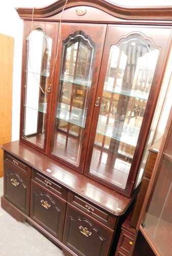 A 20thC display cabinet, the top with three glass doors enclosing a mirrored back and glass...