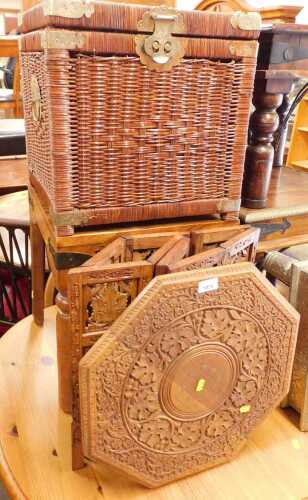 An Indian carved hardwood and brass inlaid occasional table, together with an Eastern wicker...