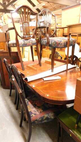 A mahogany and crossbanded extending dining table, raised on twin pedestals with sabre legs,...