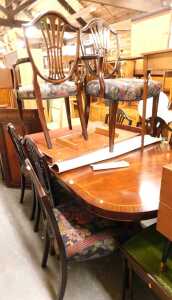 A mahogany and crossbanded extending dining table, raised on twin pedestals with sabre legs,...