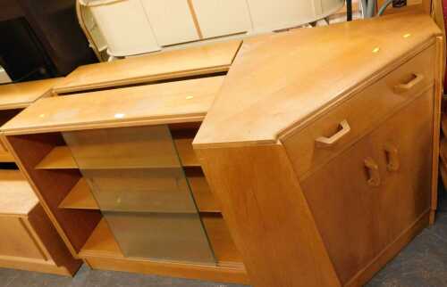A pair of oak bookcases, each with two sliding glass doors, raised on a plinth base, 87cm high,...