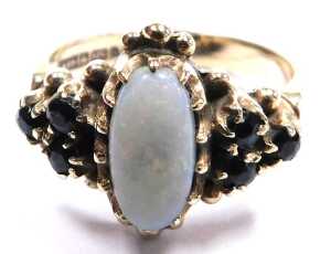 A 9ct gold opal and sapphire ring, the oval opal in a claw setting, with triple sapphire set... - 2