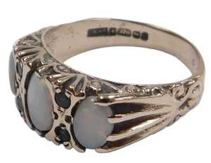 A 9ct gold and opal three stone ring, set with pairs of tiny emeralds at intervals, size O, 3.2g.