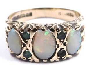 A 9ct gold and opal three stone ring, set with pairs of tiny emeralds at intervals, size O, 3.2g. - 2
