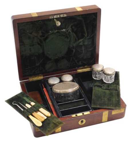A Victorian mahogany and brass bound toilet box, the hinged lid opening to reveal a fitted...