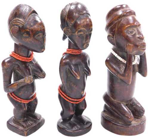 Three central African carved wooden fertility figures, each adorned with beads, 21cm high.