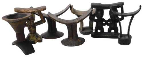 A pair of Ethiopian carved wooden headrests, three further headrests, a Hemba figural headrest,...
