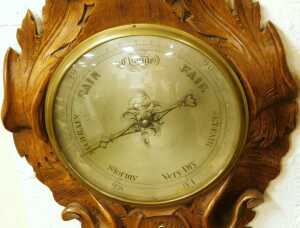 A Victorian oak wheel barometer, with a silvered dial, and thermometer, the case carved in high... - 2