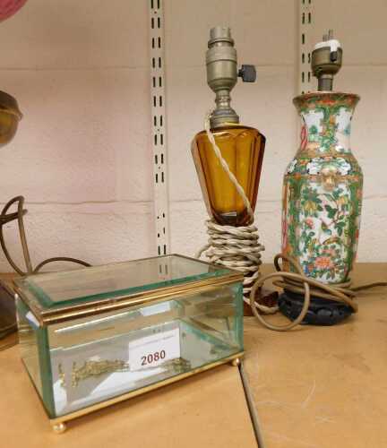 A Cantonese famille rose porcelain vase converted to a lamp, together with an amber glass lamp,...