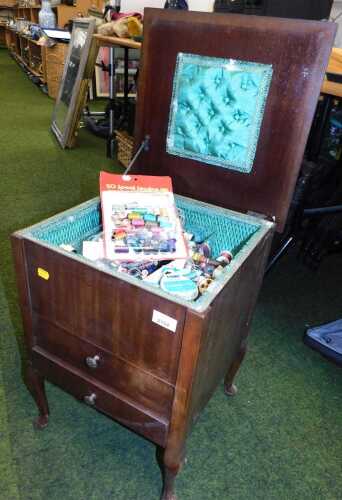 A wooden side sewing cabinet, together with sewing paraphernalia.
