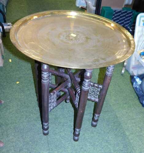 An Indian brass tray table with a folding wooden base.