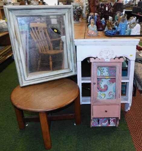 A group of furniture, comprising a distressed pink painted hanging cabinet, with an undulating...