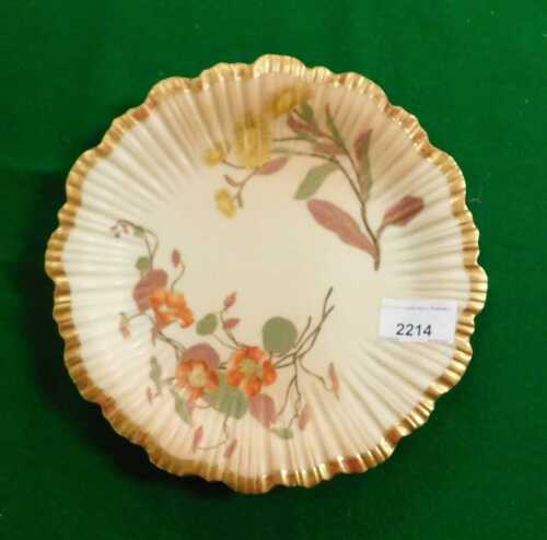 An early 20thC Royal Worcester blush porcelain plate, with a gilt scalloped edge and depictions...