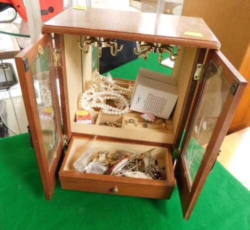 A glass fronted jewellery wardrobe, containing a strand of pearls, a silver plated possibly opal...