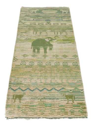 A green ground rug, possibly Indian, decorated with an elephant, horses, "UPS UPS" and floral...