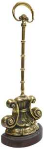 An early Victorian brass and iron doorstop, cast with scrolls, with a loop handle, 28cm high.