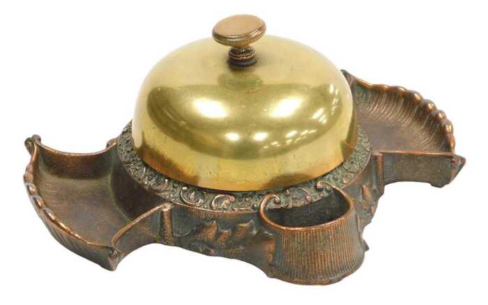 A late 19thC cast copper and brass hotel desk bell and match strike, stamped to underside Russel...