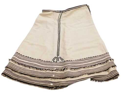 A Xhosa Thembu Senior Man's Itshali skirt, in cream, with black piping and banded decoration,...
