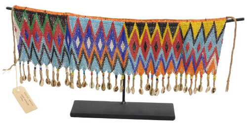 A Kirdi apron, from Chad, with a shell and beadwork fringe, with display stand.