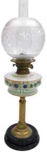 An early 20thC oil lamp, with a globular etched shade, an opaque cream glass reservoir decorated...