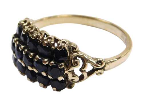 A 9ct gold and sapphire ring, set with three rows, each of five brilliant cut sapphires, in a...