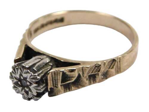 A 9ct gold and diamond solitaire ring, in a high claw illusion setting, with engraved shoulders,...