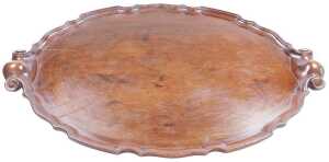 A George III style mahogany oval tray, with a piecrust border and scroll handles, 68cm x 49.5cm.