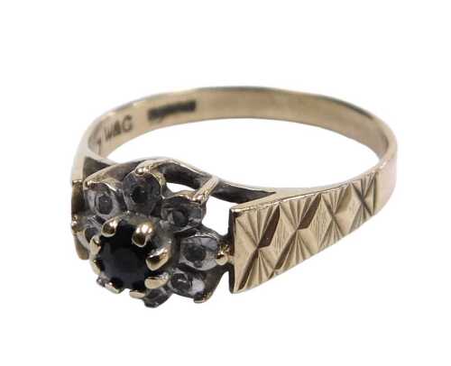 A 9ct gold sapphire and diamond flower head ring, the central sapphire in a surround of tiny...