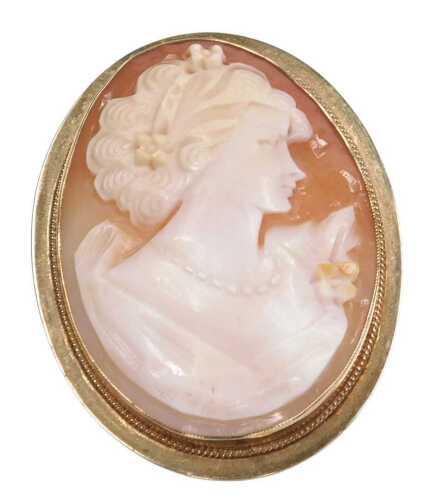 A shell cameo brooch, bust portrait of a lady, in an oval yellow metal frame, unmarked.