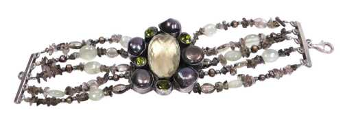 A four strand bracelet, set centrally with a large faceted crystal, green pastes and black fresh...