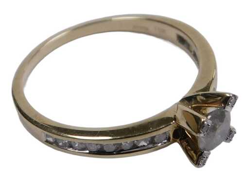 A 9ct gold diamond dress ring, the central stone having illusion set pegs and channel set...