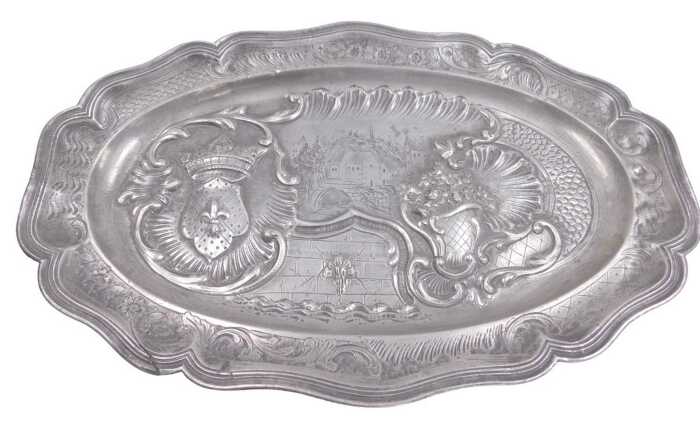 A Continental pewter meat dish or charger, cast with a crest, scrolls, flowers, etc., around a...