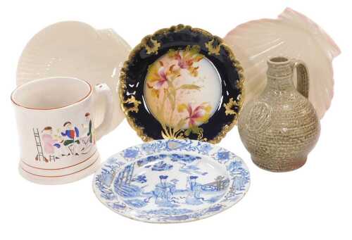 A group of pottery and porcelain, including a frog tankard, Belleek porcelain scallop shell...