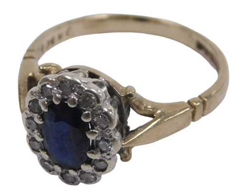 A 9ct gold sapphire and diamond ring, the oval cut sapphire in a surround of brilliant cut...