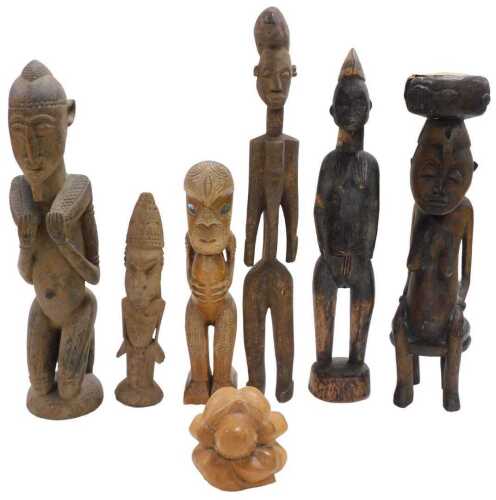 A group of African figural carvings, including fertility figures, together with a Maori Tekoteko,...